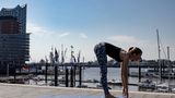 Frau in Sportklamotten beim Yoga.