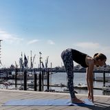 Frau in Sportklamotten beim Yoga.