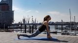 Frau in Sportklamotten beim Yoga.