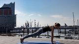 Frau in Sportklamotten beim Yoga.