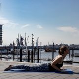 Frau in Sportklamotten beim Yoga.