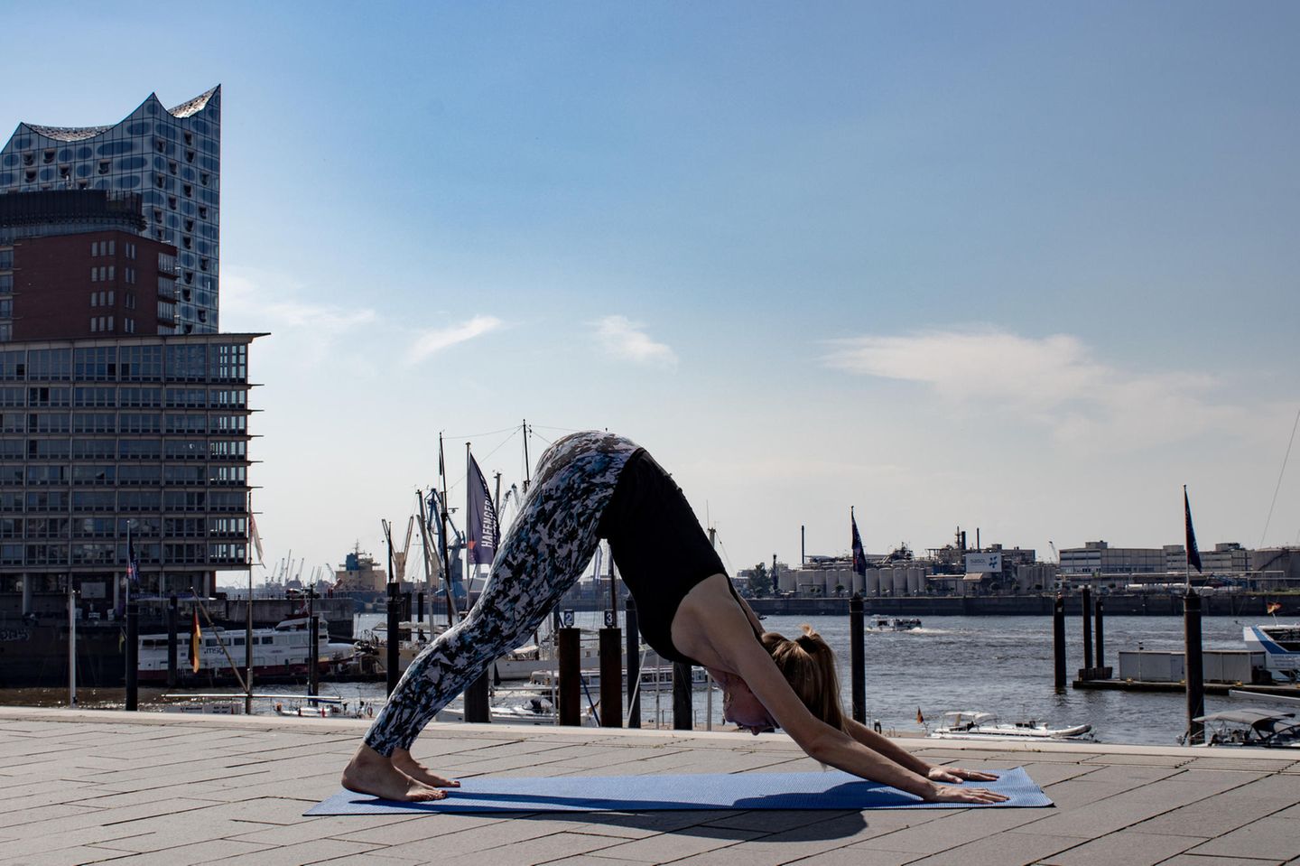 Frau in Sportklamotten beim Yoga.