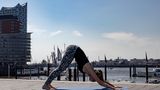 Frau in Sportklamotten beim Yoga.
