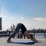 Frau in Sportklamotten beim Yoga.