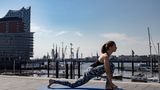 Frau in Sportklamotten beim Yoga.