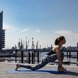 Frau in Sportklamotten beim Yoga.