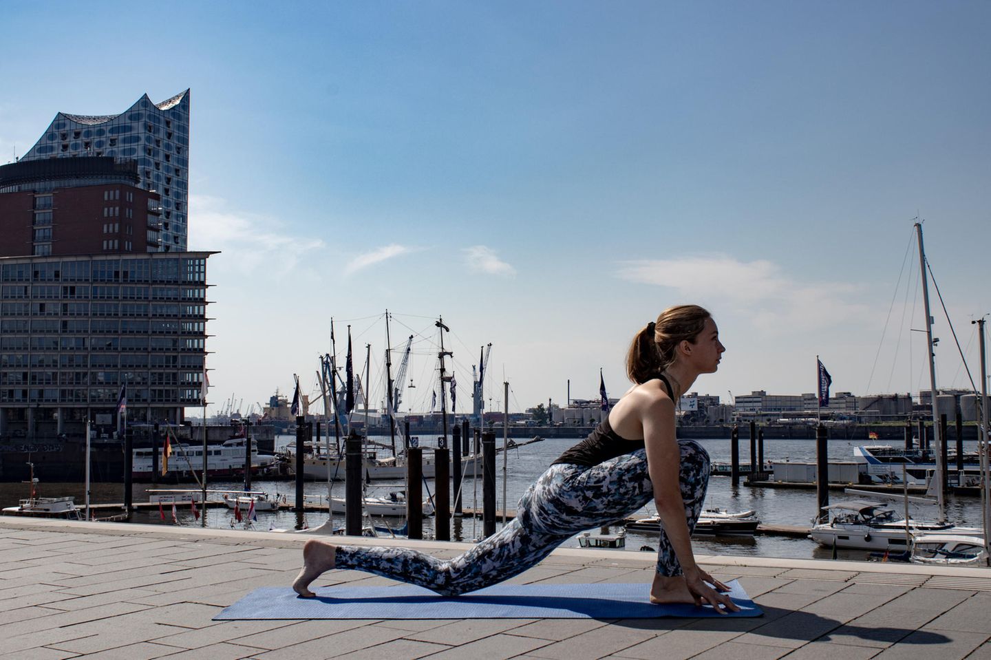 Frau in Sportklamotten beim Yoga.