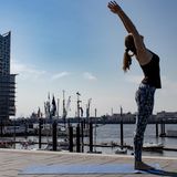 Frau in Sportklamotten beim Yoga.