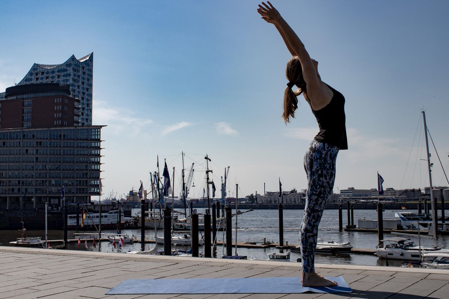 Frau in Sportklamotten beim Yoga.