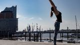 Frau in Sportklamotten beim Yoga.