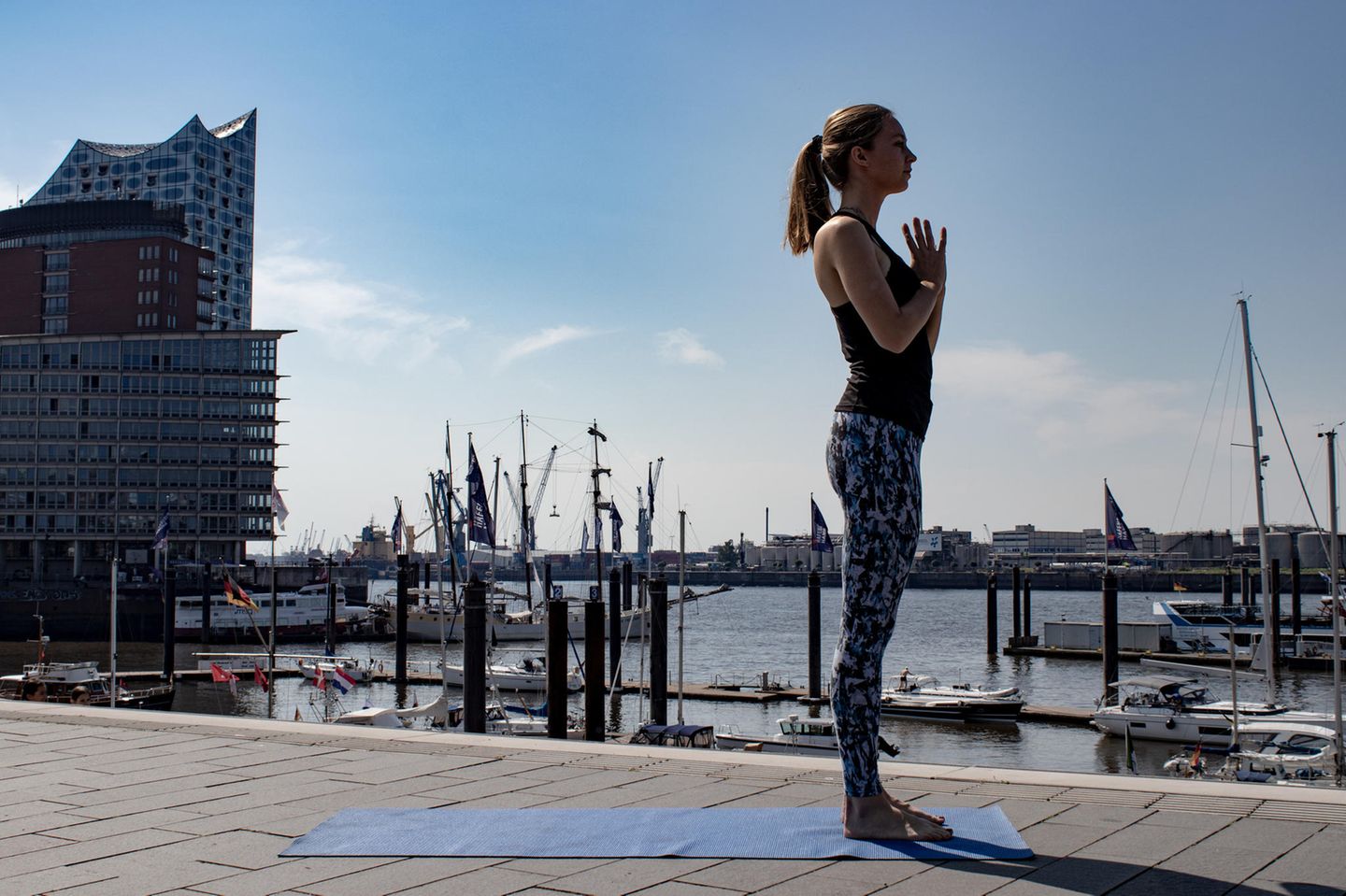 Frau in Sportklamotten beim Yoga.