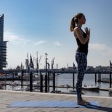 Frau in Sportklamotten beim Yoga.