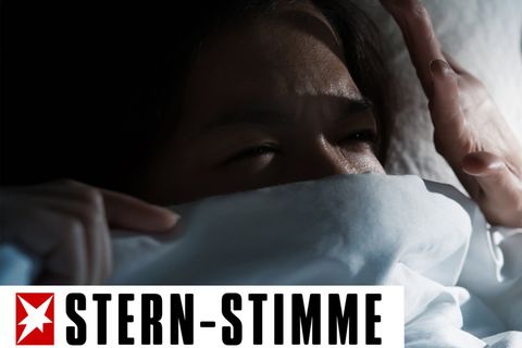 Frau im Bett im dunklen Zimmer