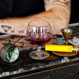 El cielo rojo  "Der rote Himmel“ stieg einst in Guatemala am Haus über den Wolken auf und brachte auf 2300 Höhenmeter würzige Aromen aus den Fässern mit rotem Wein und Schokolade zusammen.Die Weltreise im Ballon beginnt hier! Bei diesem Drink handelt es sich um eine abgewandelte Art eines klassischen Rum-Manhattans, die durch Rotwein-Noten unterstützt wird.      Zutaten:  Ron Zacapa 23  Noilly Prat Red Vermouth  Rotwein-Essenz  Bitters