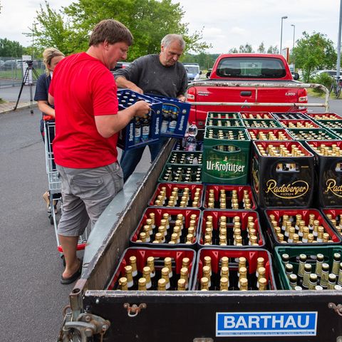 Protest gegen Neonazis in Ostritz: Zwei Männer beladen einen Anhänger mit Bierkisten aus einem örtlichen Supermarkt