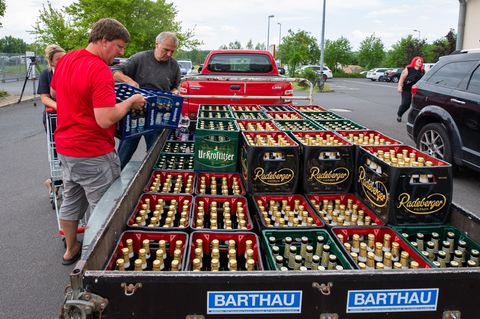 Protest gegen Neonazis in Ostritz: Zwei Männer beladen einen Anhänger mit Bierkisten aus einem örtlichen Supermarkt