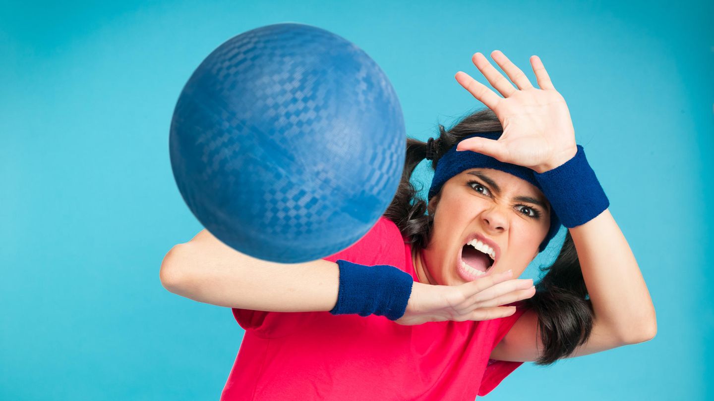 Eine Frau wird beim Völkerball von einem Ball getroffen