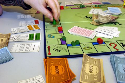 Ein Mensch spielt Monopoly
