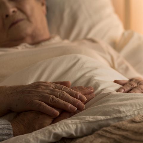 Ein gebrechlicher alter Mann liegt im Bett