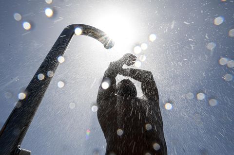 Ein Badegast duscht sich im Strand- und Freibad nach dem Baden im Bodensee. Rund 20 Grad hat der Bodensee bei Friedrichshafen.
