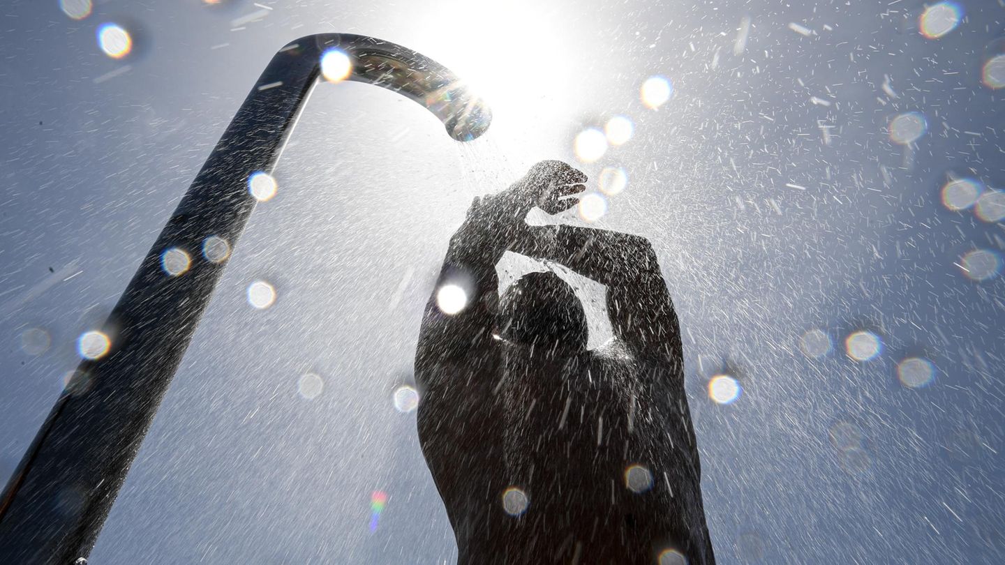 Ein Badegast duscht sich im Strand- und Freibad nach dem Baden im Bodensee. Rund 20 Grad hat der Bodensee bei Friedrichshafen.
