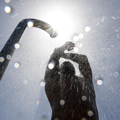 Ein Badegast duscht sich im Strand- und Freibad nach dem Baden im Bodensee. Rund 20 Grad hat der Bodensee bei Friedrichshafen.