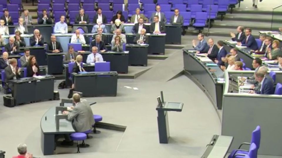 Ein Mann hält eine Rede im Bundestag.