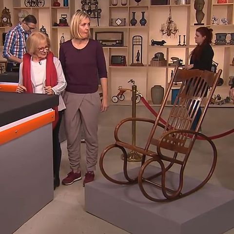 "Bares für Rares"-Experte Albert Maier (r.) begutachtet den Schaukelstuhl, den die beiden Verkäuferinnen los werden wollen.