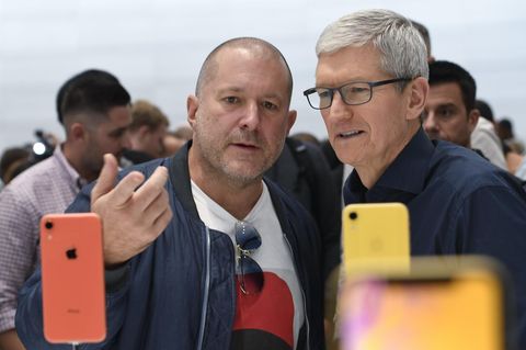 Designchef von Apple John Ive schaut sich mit einem zweiten Mann iPhones an.