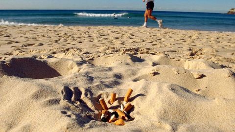 Zigarettenkippen liegen an einem Strand