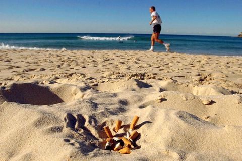 Zigarettenkippen liegen an einem Strand