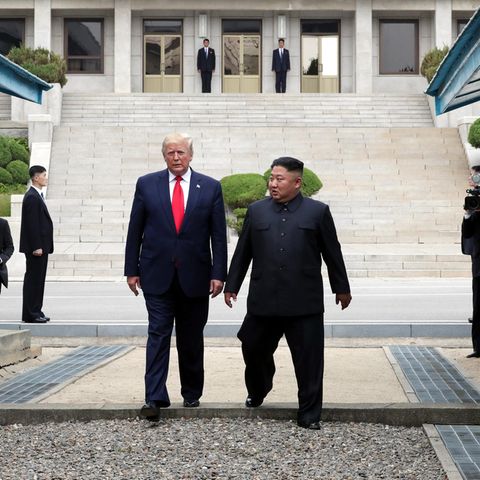 Kim Jong-Un und Donald Trump gehen gemeinsam über die Grenze zwischen Nord- und Südkorea.