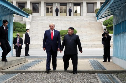 Kim Jong-Un und Donald Trump gehen gemeinsam über die Grenze zwischen Nord- und Südkorea.