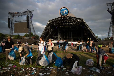 Mit Müllbeuteln ausgestattet, räumen Helfer das Festivalgelände auf