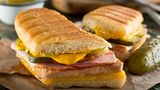 Cuban Sandwich  Das vor allem im Süden der USA beliebten Sandwich wird auch Cubano genannt. Und es kommt nicht, wie der Name vermuten lässt, aus Kuba. Aber Kubaner haben ein ähnliches Sandwich mit Fisch und Cassava-Brot gemacht, die Spanier brachten den Käse, das Weißbrot und das Schweinefleisch dazu. Anfang der 1800er Jahre florierte der Tabakimport zwischen Kuba und Südflorida. Die Arbeiter brauchten einen schnellen Snack, so wurde das Sandwich geboren. Heute kennt man das Cubano mit gebratenem Schweinefleisch, Schinken, Schweizer Käse und Essiggurke. 