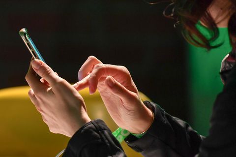 Eine Frau tippt auf ihrem Handy.