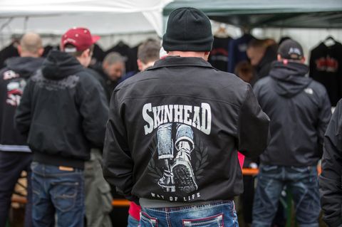 Publikum in schwarzen Jacken mit Skinhead-Logos