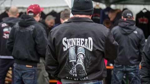 Publikum in schwarzen Jacken mit Skinhead-Logos