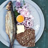 Røget Sild - traditionell geräucherter Hering  Zutaten: 2 ganze Heringe  Beilagen: 2 EL Schnittlauch, gehackt, 4 Radieschen, hauchdünn geschnitten (wenn möglich, mithilfe einer Mandoline),1 kleine Zwiebel, in dünne Ringe geschnitten, 25 g Butter, 2–4 dünne Scheiben Roggenbrot, 1 Eigelb vom sehr frischen Bio-Ei, Meersalz, 2–4 Schnittlauchblüten (optional)      Zubereitung: Zum Servieren je einen geräucherten Hering auf einen Teller legen und auch die Beilagen gleichmäßig verteilen. Sollten Schnittlauchblüten erhältlich sein, die Blütenblätter abzupfen und auf die Teller streuen. Die Brotscheiben leicht mit Butter bestreichen, die Fischhaut entfernen, das Fischfleisch in Stücke zupfen und auf das Brot geben. Mit den Zwiebelringen und den Radieschen belegen. Mit etwas Eigelb bestreichen und mit Meersalz und Schnittlauchblüten bestreuen.