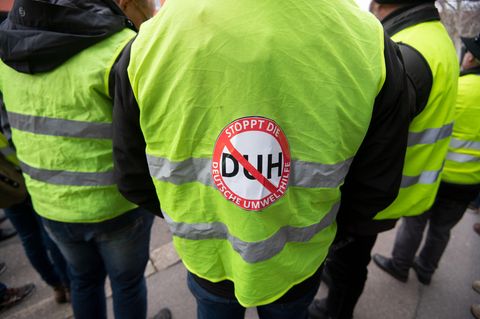 Menschen in Warnwesten protestieren gegen die deutsche Umwelthilfe