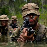 Marine John Allen, ein Royal Marine Commando , mit Soldaten von Armee und Marine bei einer Übung in Belize-