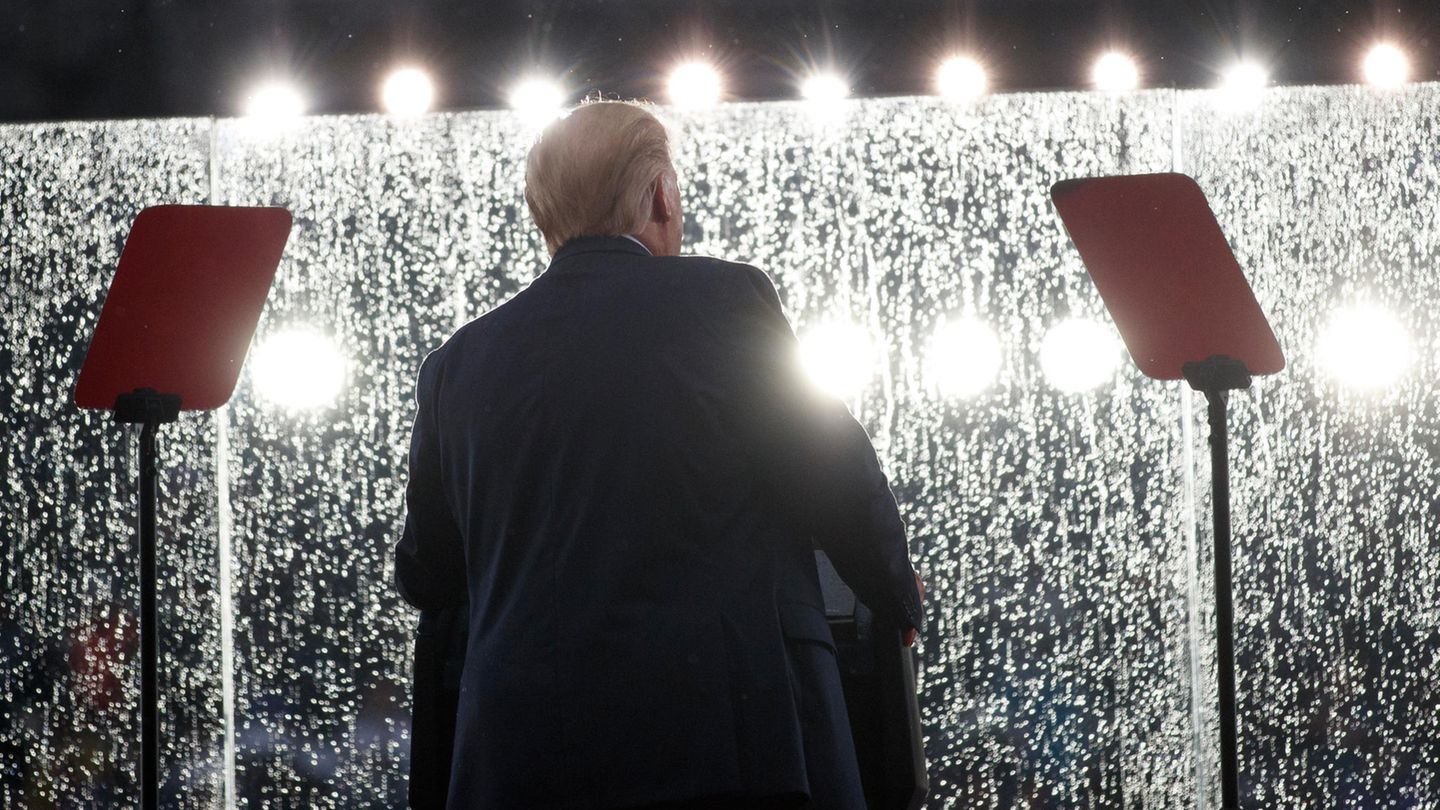 Donald Trump vor der völlig verregneten und verschmierten Glaswand