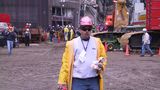Ein Arbeiter mit Helm und gelber Regenjacke