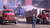 Ein Arbeiter sitzt auf einem Tankwagen und löscht den aufsteigenden Staub aus dem Schutt