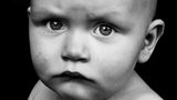 Ein Baby schaut mit hochgezogenen Augenbrauen ernst in die Kamera