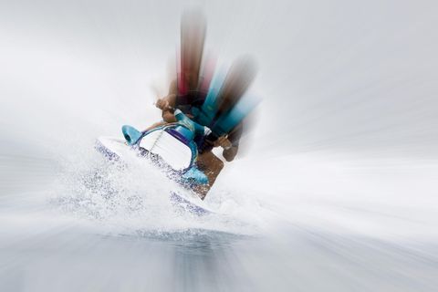 Ein Jetski mit zwei Personen fährt schnell über das Meer