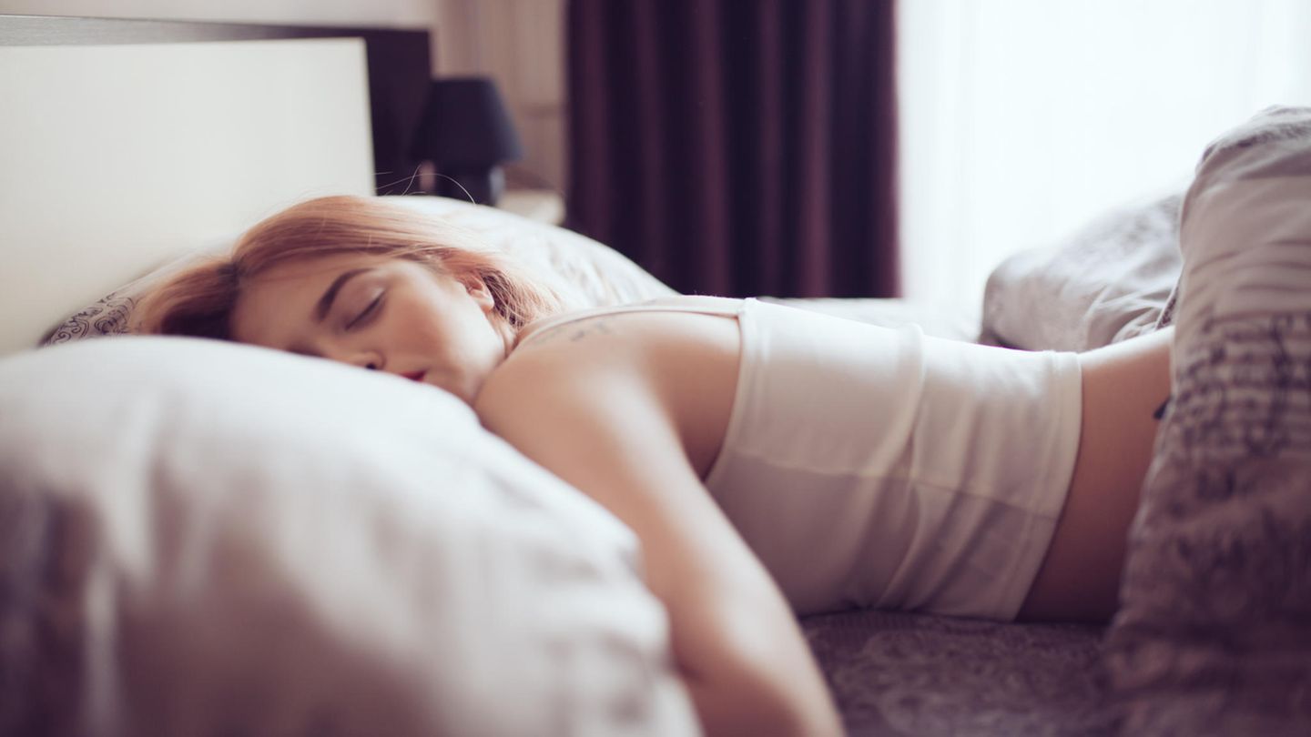 Ursachen für Müdigkeit: Eine Frau liegt im Bett und schläft