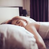 Ursachen für Müdigkeit: Eine Frau liegt im Bett und schläft