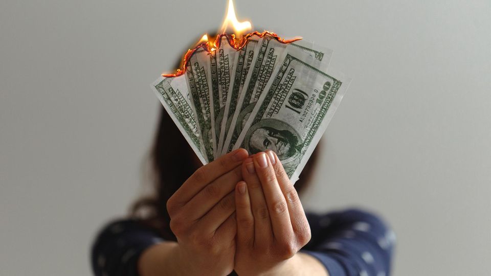 Frau mit brennenden Geldscheinen