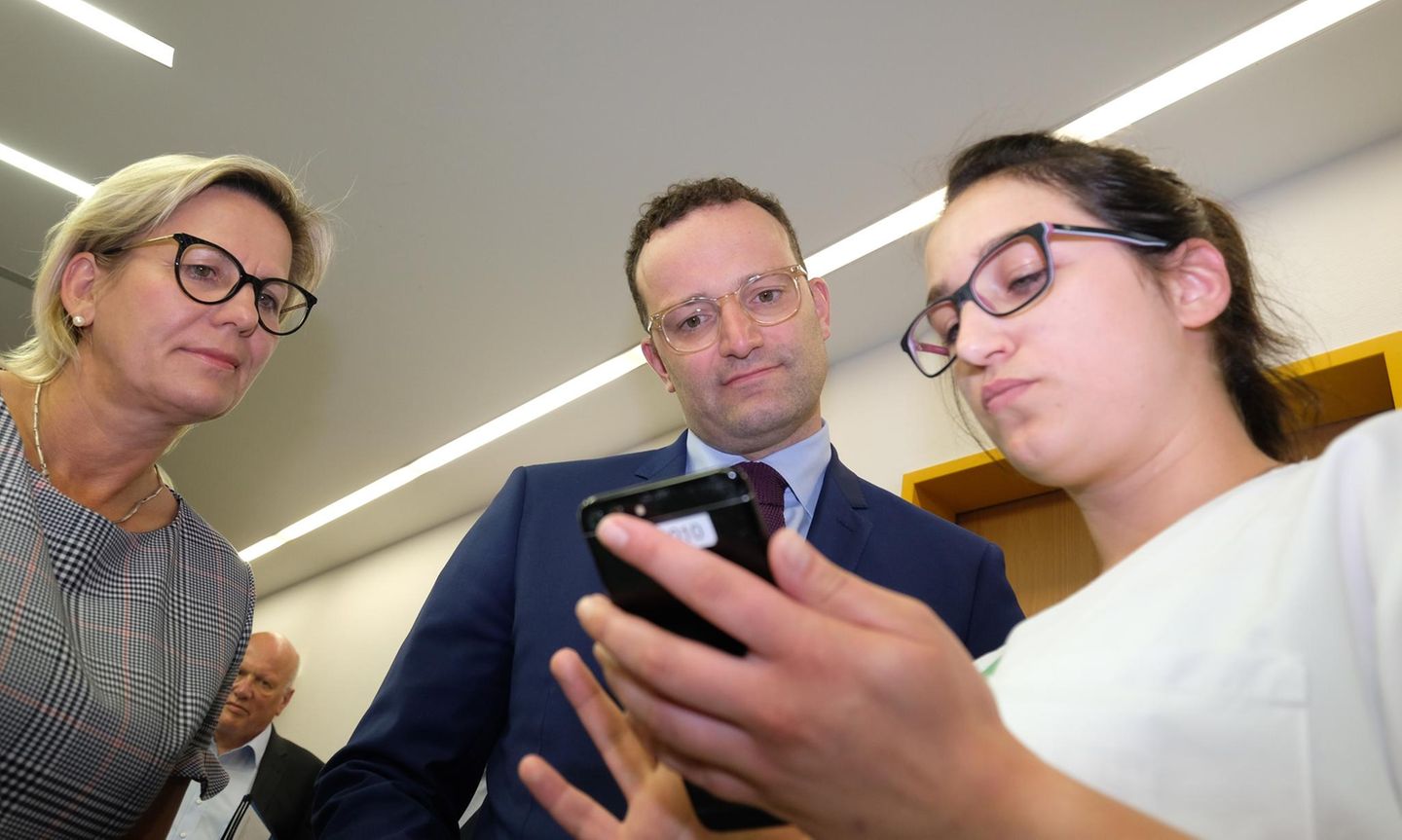 Jens Spahn schaut mit der sächsischen Sozialministerin Barbara Klepsch auf eine Klinik-App in Zwickau
